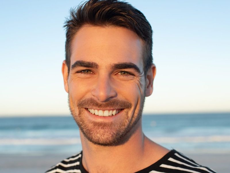 Portrait of happy man standing on the beach Portrait of happy man standing on the beach
